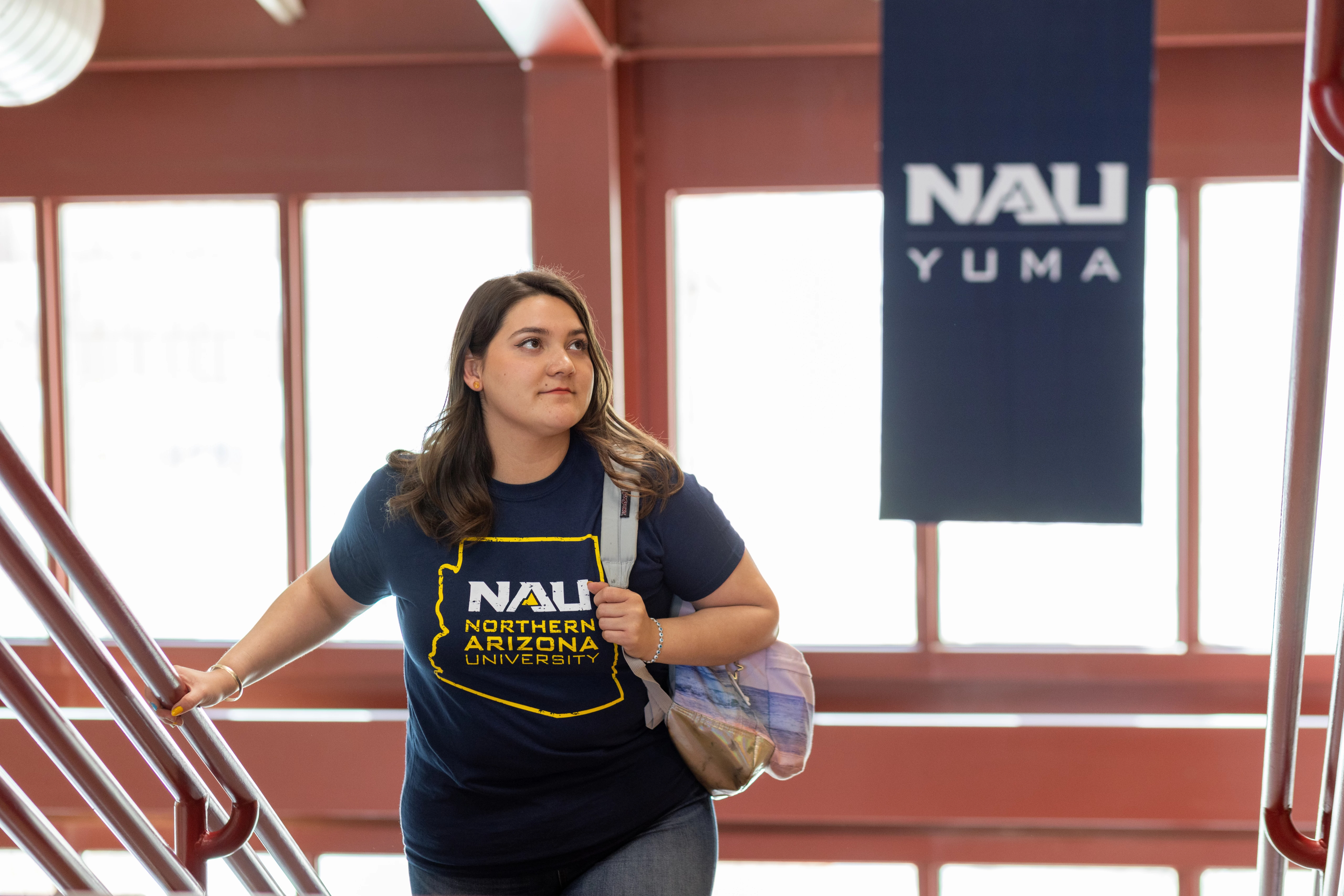 Student walking up a staircase at N A U–Yuma.